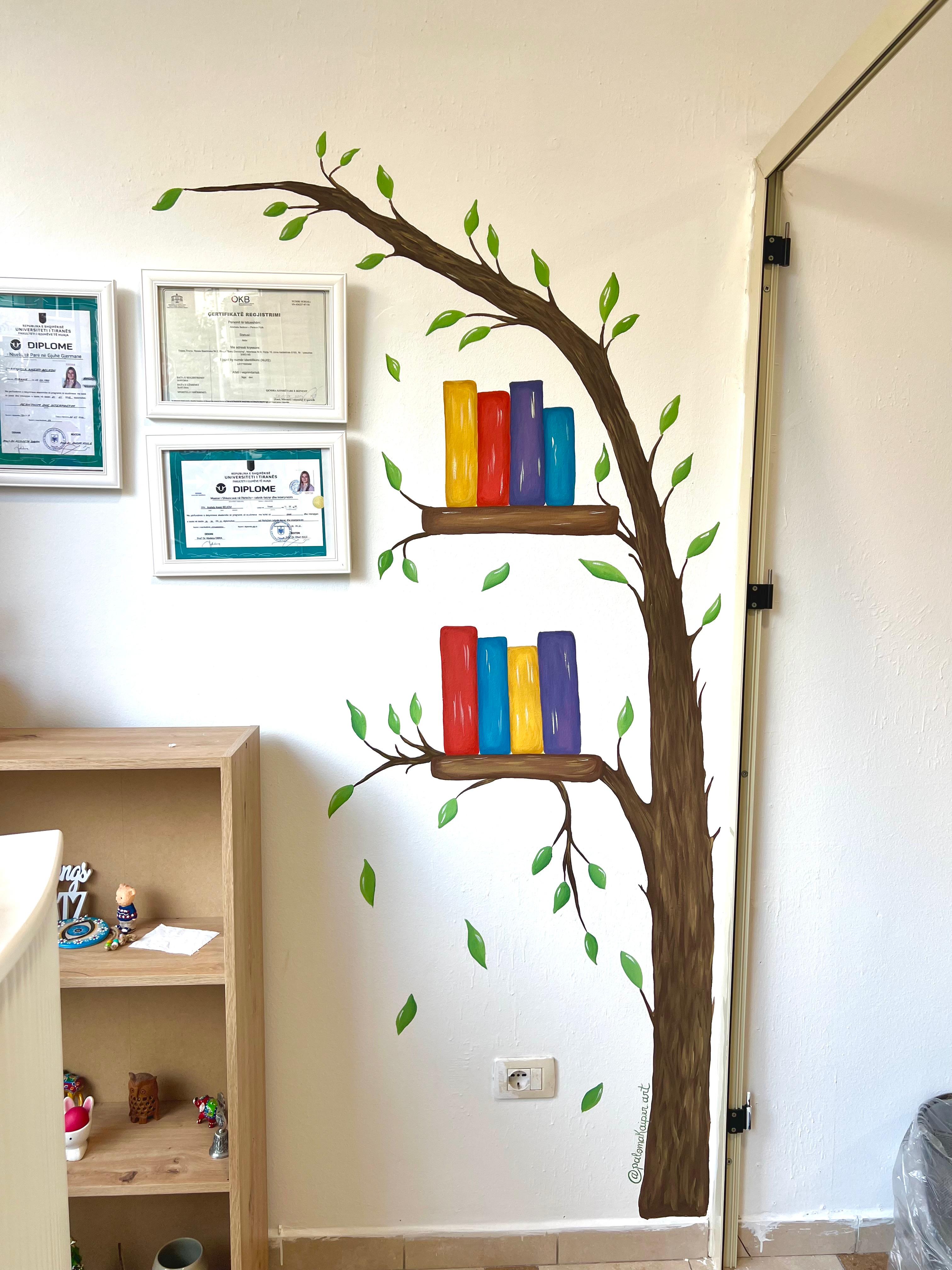 Full view of the mural of a tree with books resting on its branches