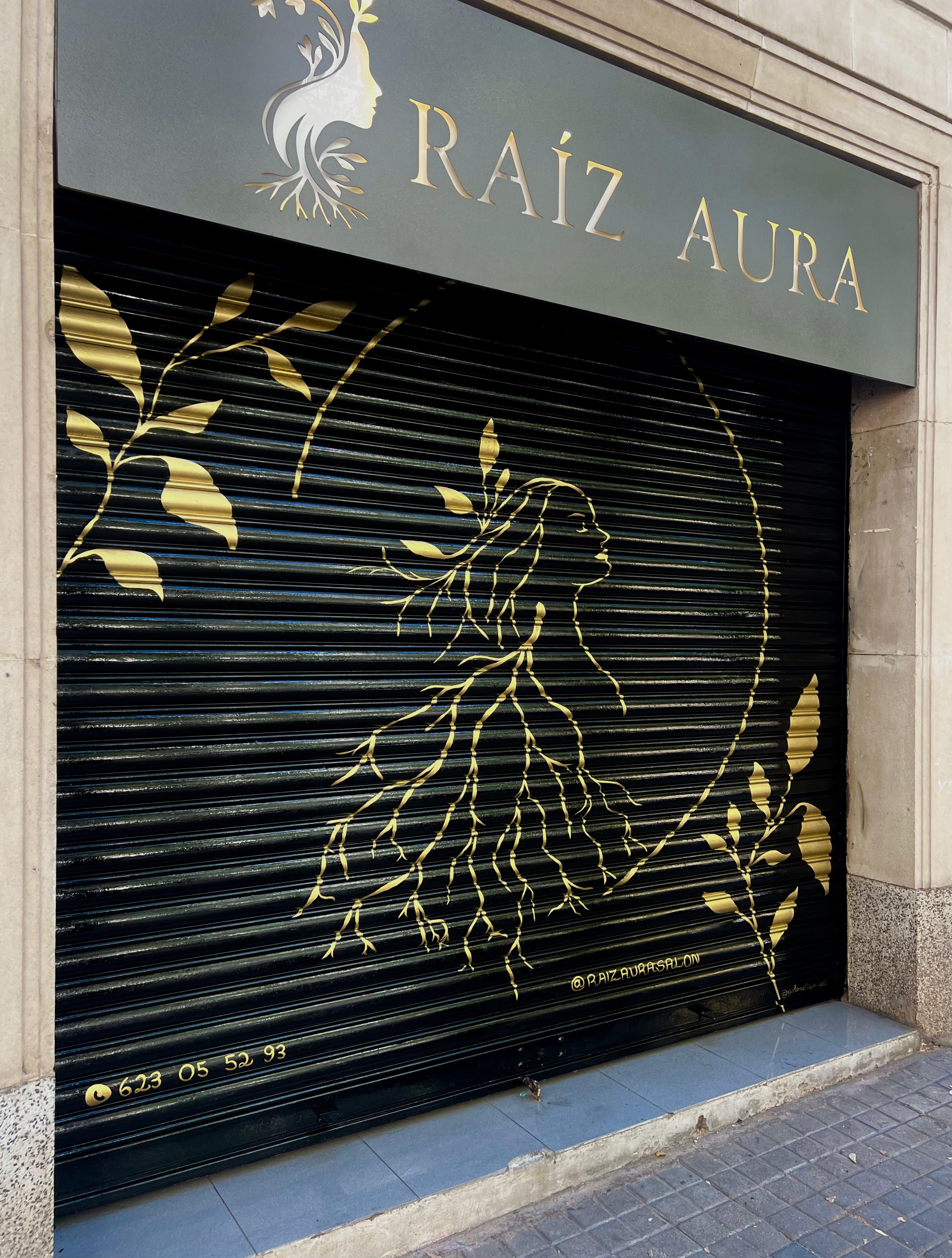 Full view of the gold artwork on a salon’s black shutter