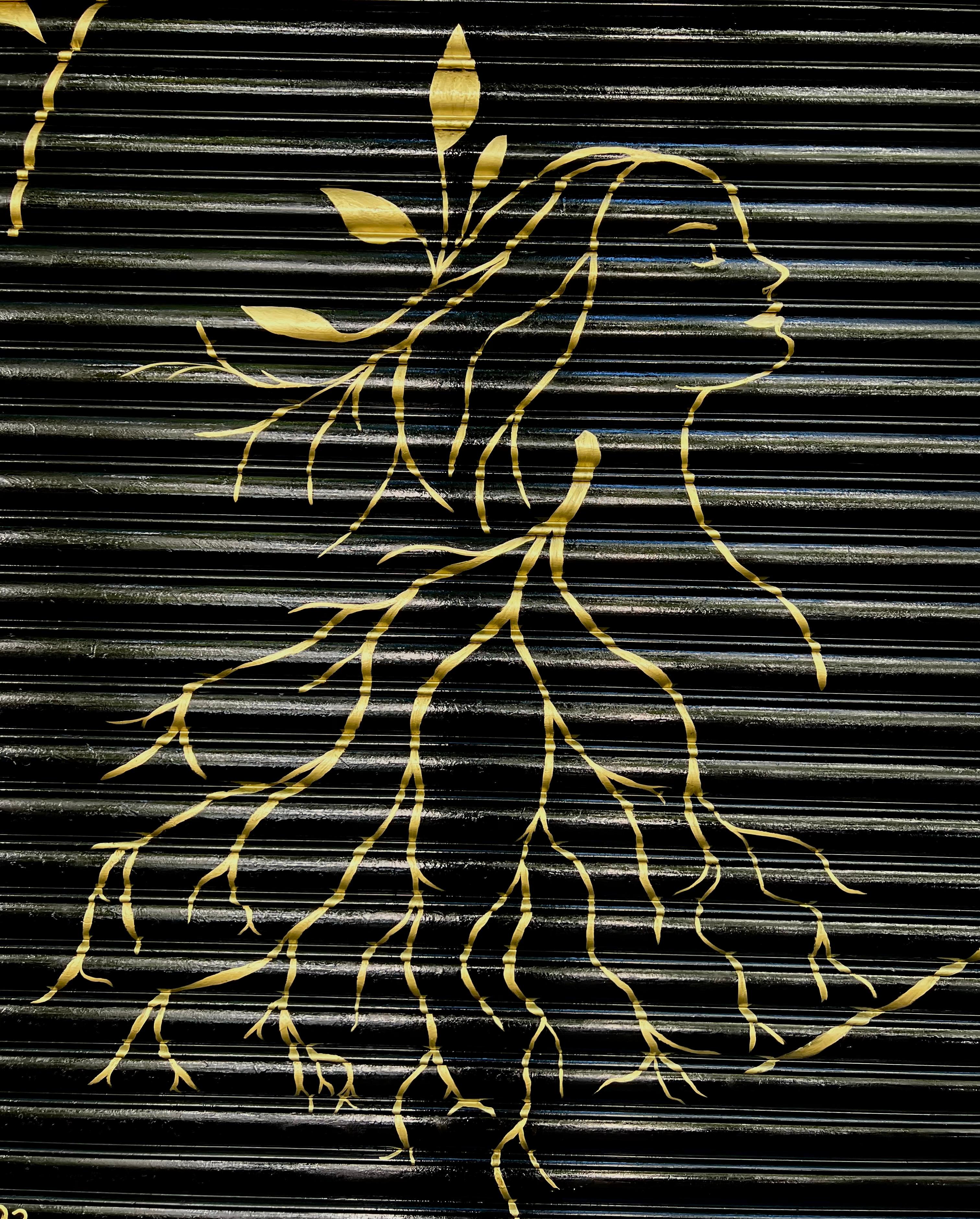 Detail of a woman’s profile drawn in gold on the black shutter